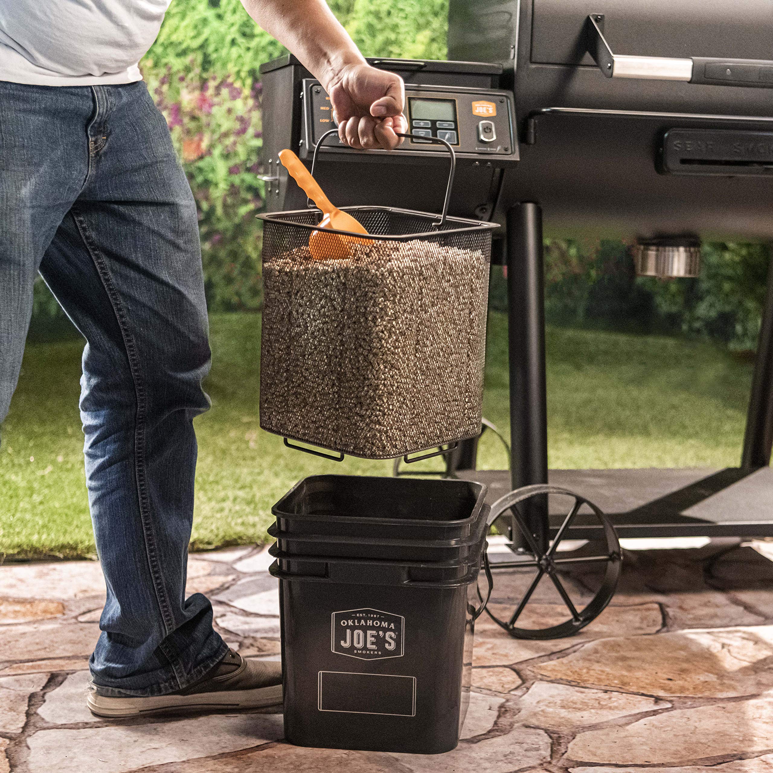 Oklahoma Joe's bucket placed beside grill for organized, ready-to-use pellets