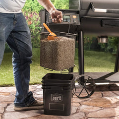 Oklahoma Joe's bucket placed beside grill for organized, ready-to-use pellets