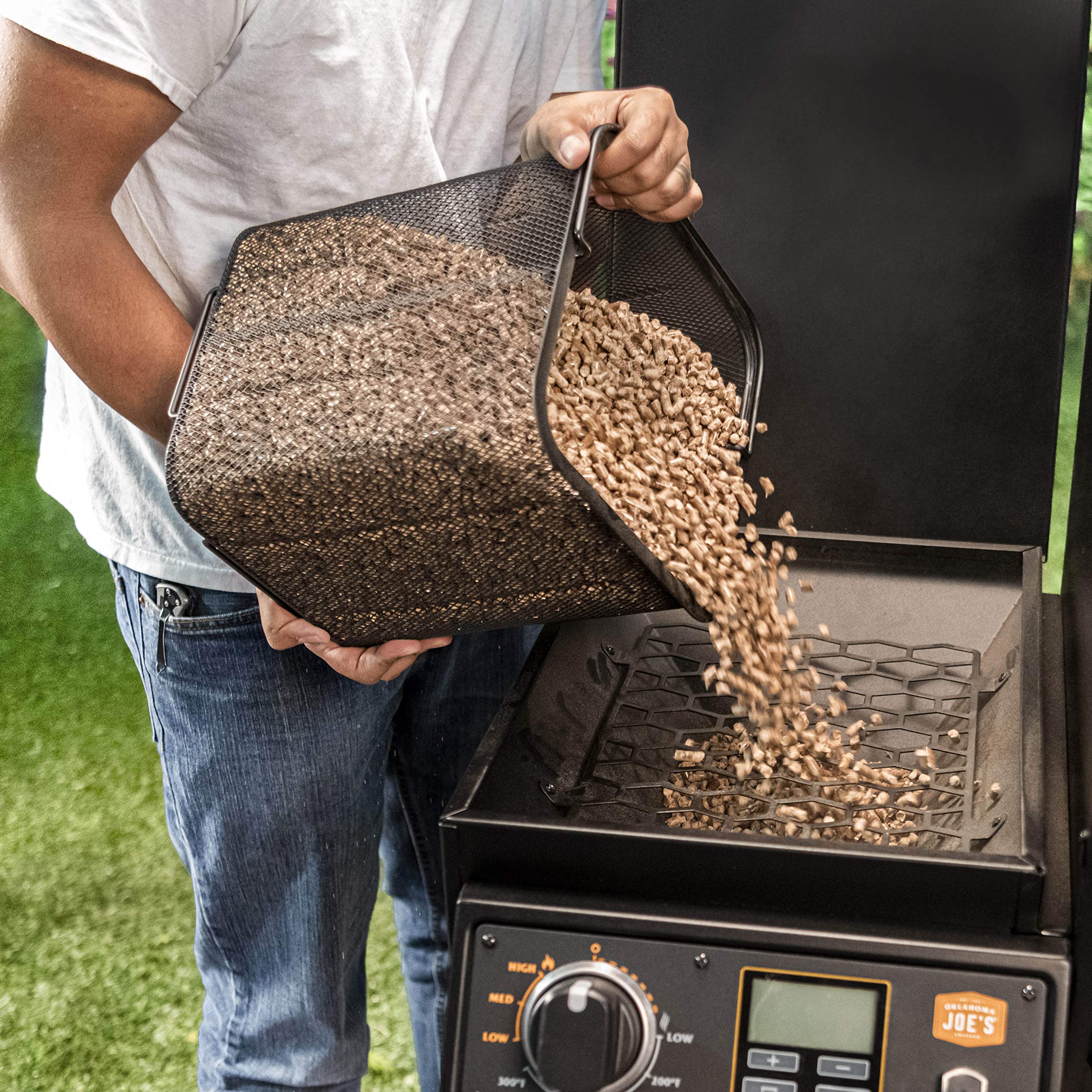 Oklahoma Joe's scoop transferring pellets into hopper for neat loading