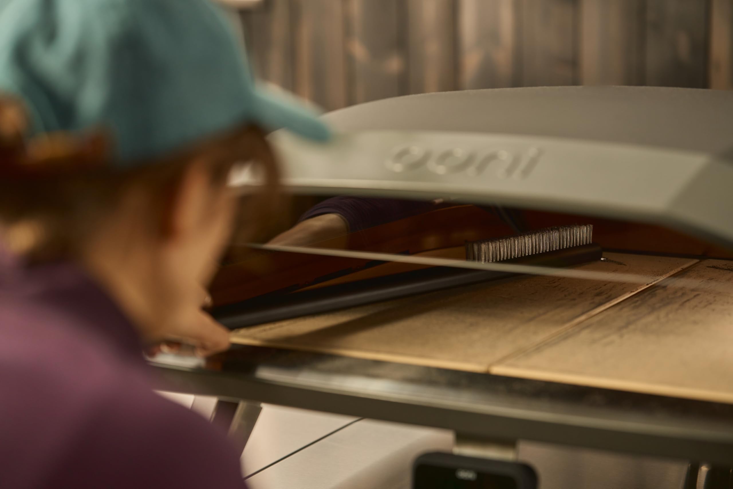 ooni using brush and scraper cleaning pizza stone for faster prep