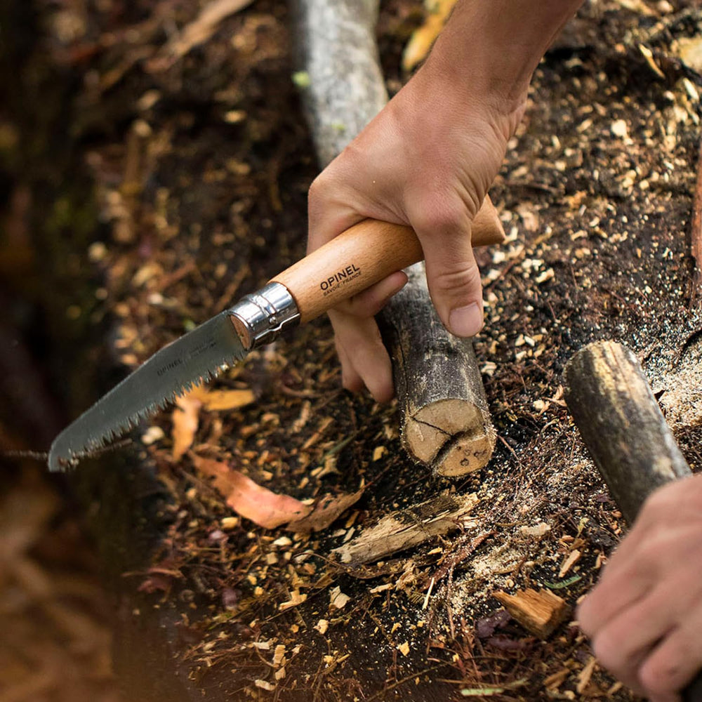 Opinel saw cutting branch in garden for quick pruning efficiency