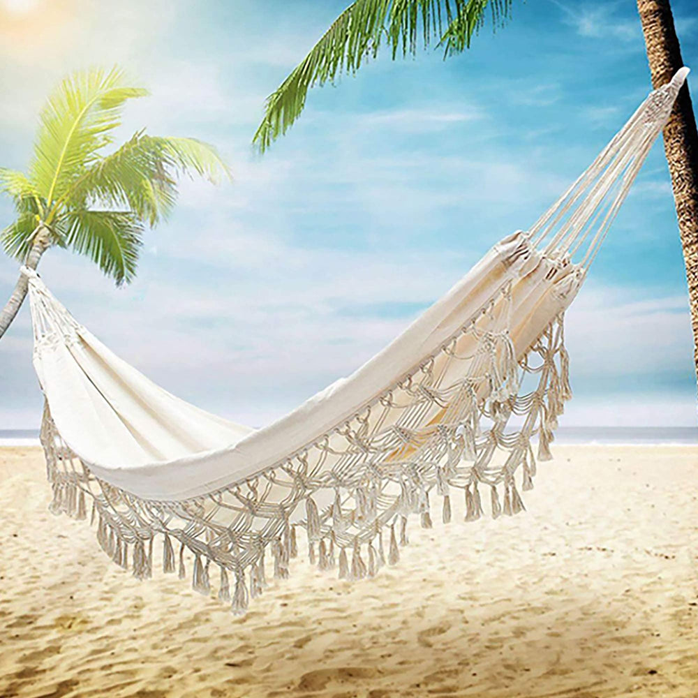 ORANGE NEI hammock hung between trees outdoors demonstrating portable relaxation