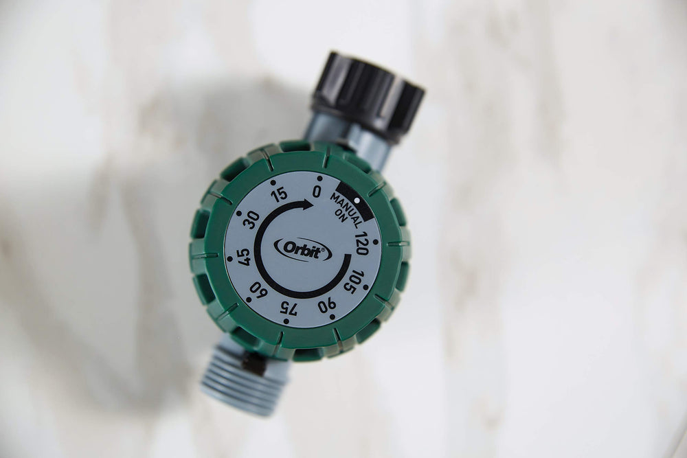 Orbit attached to outdoor spigot in use delivering timed watering without batteries