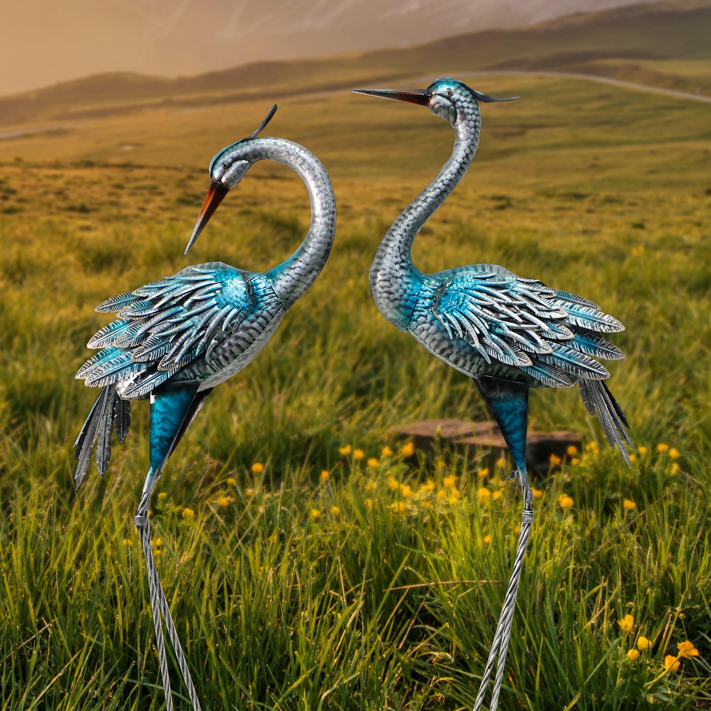 Oritty paired heron statues in garden bed adding vertical structure and charm