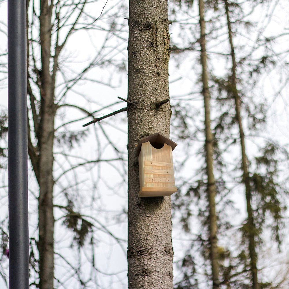 Outer Trails owl house in backyard setting illustrating natural integration into gardens and woodlots