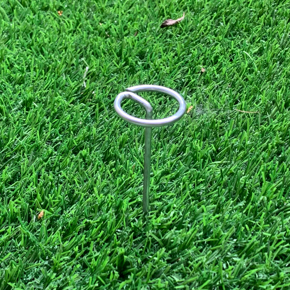 Palmhomee staples driven into soil demonstrating strong hold benefit