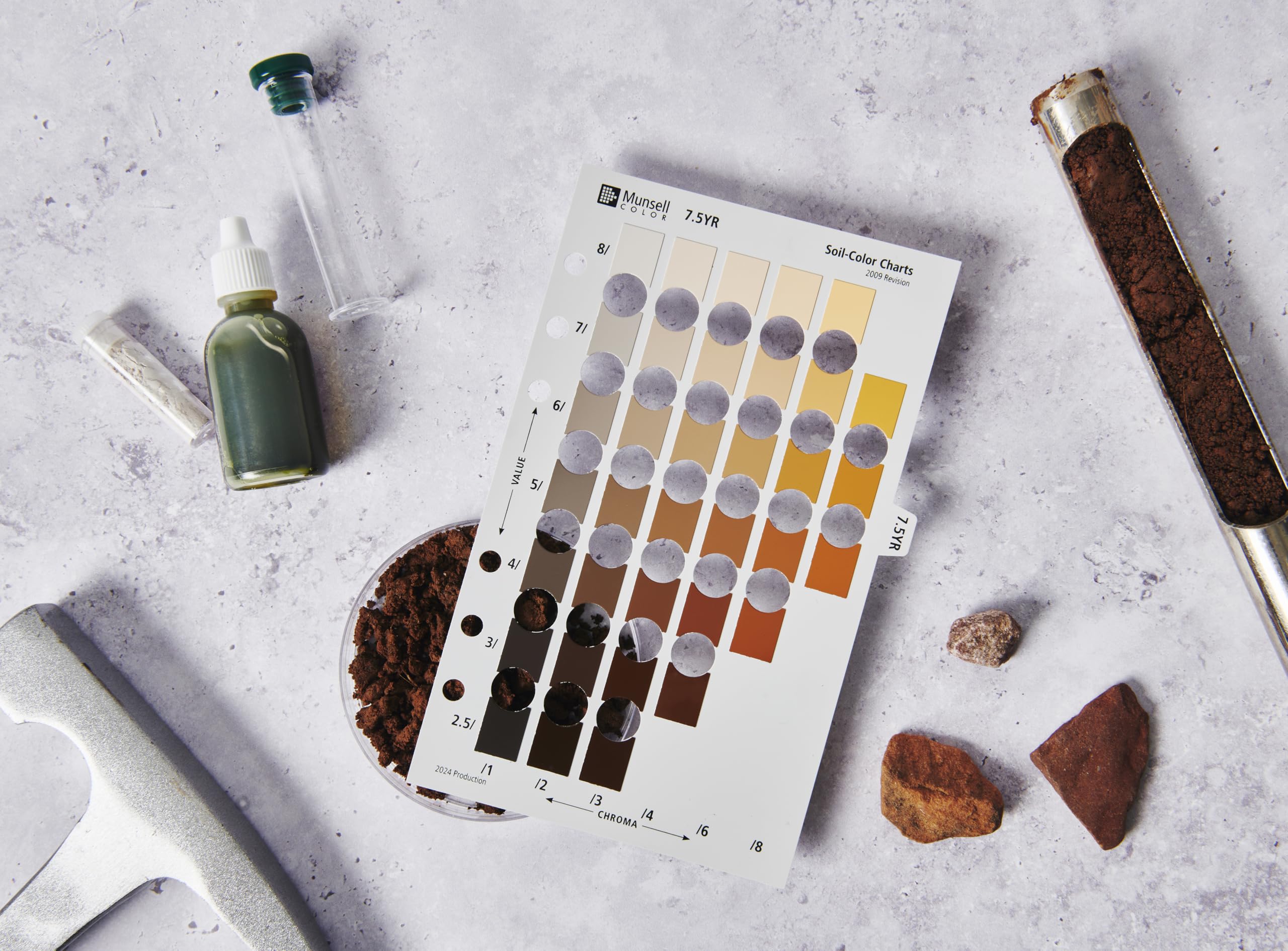 Pantone Munsell book held at a dig site matching soil color, aiding quick field recording
