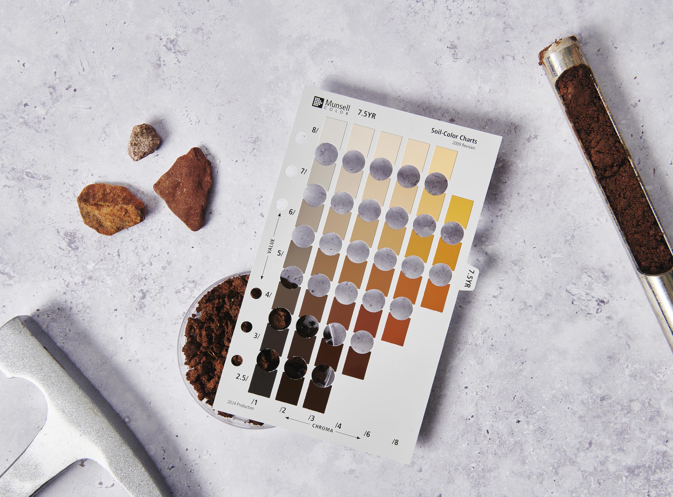 Pantone Munsell binder beside a hand for scale, demonstrating portable, classroom-ready size