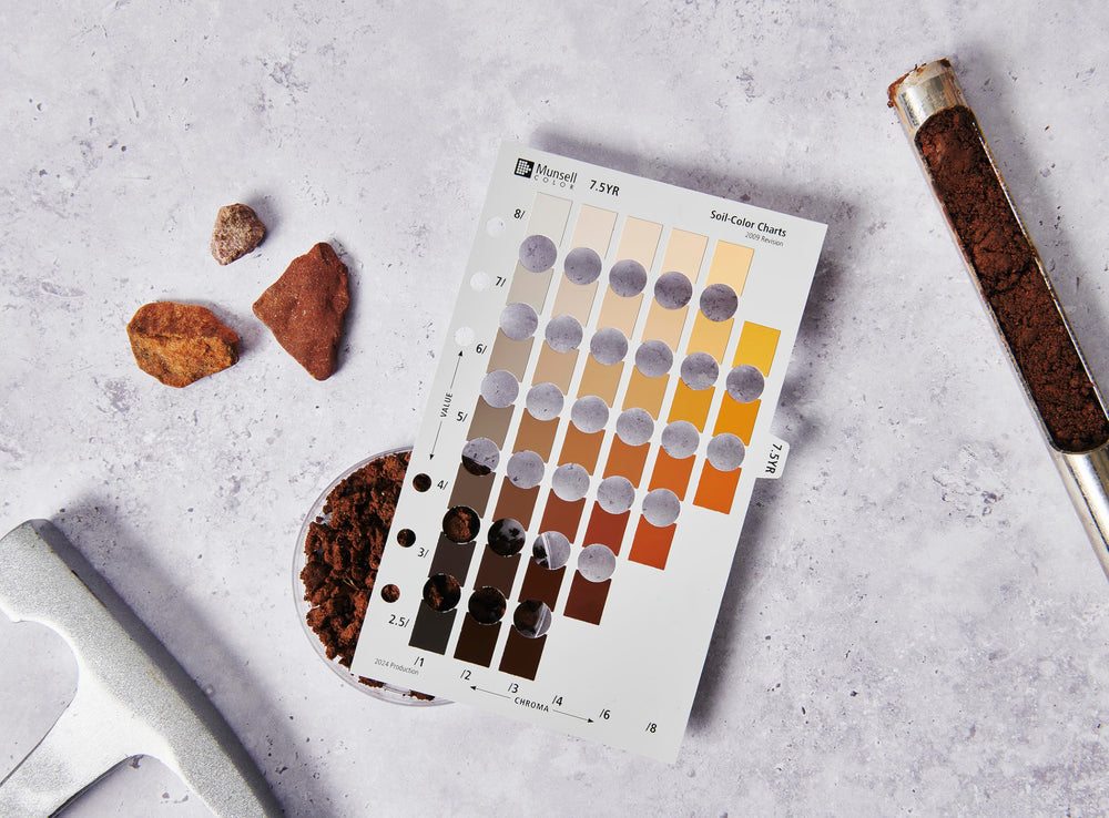 Pantone Munsell binder beside a hand for scale, demonstrating portable, classroom-ready size