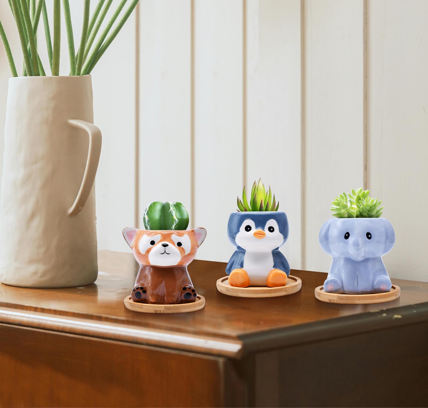 Photken penguin planter side-by-side with a pen illustrating compact size