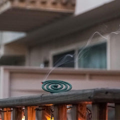 PIC coil burning in holder outdoors showing steady smoke for mosquito reduction
