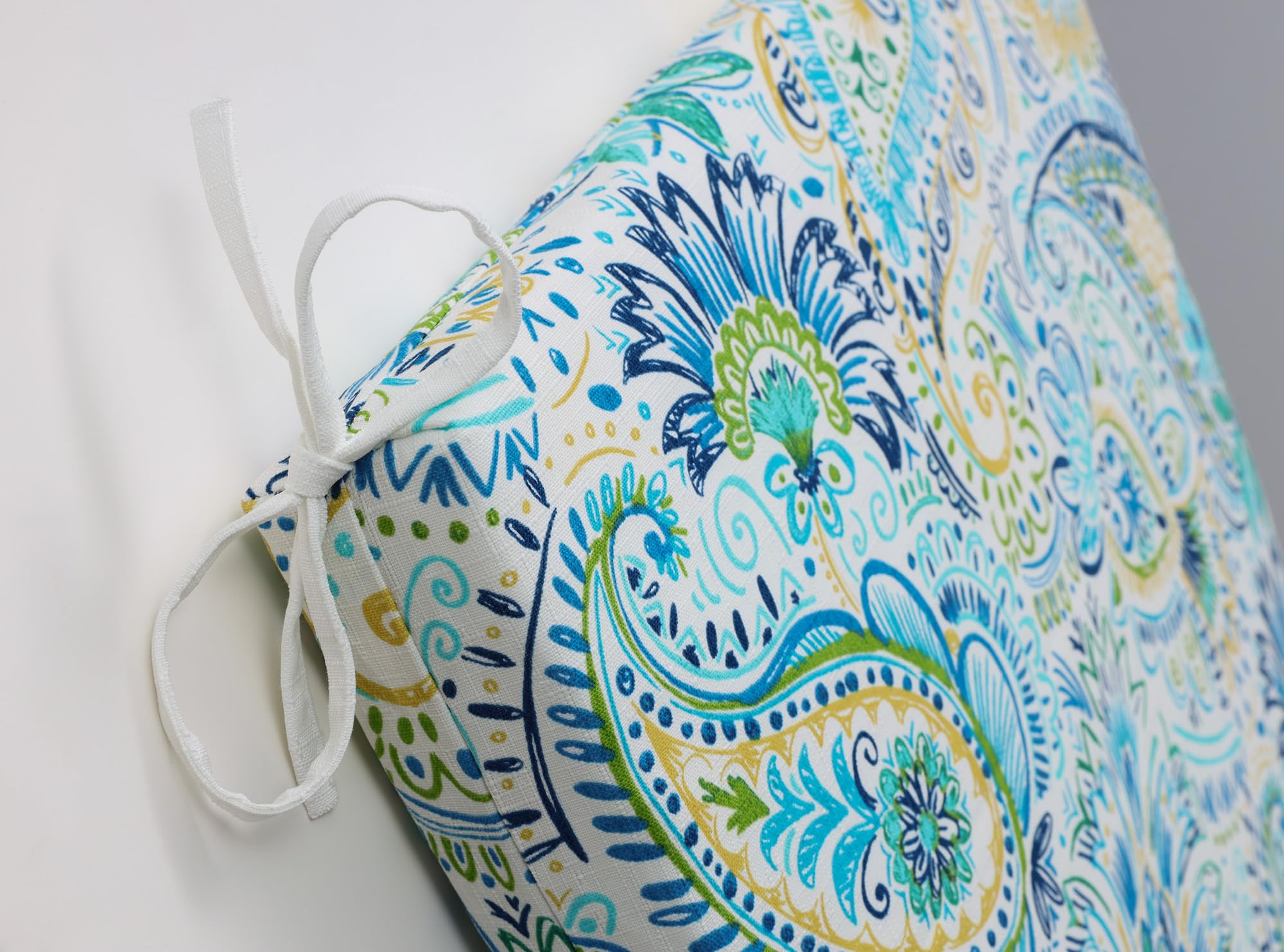 Pillow Perfect Gilford placed on patio chair demonstrating outdoor use comfort