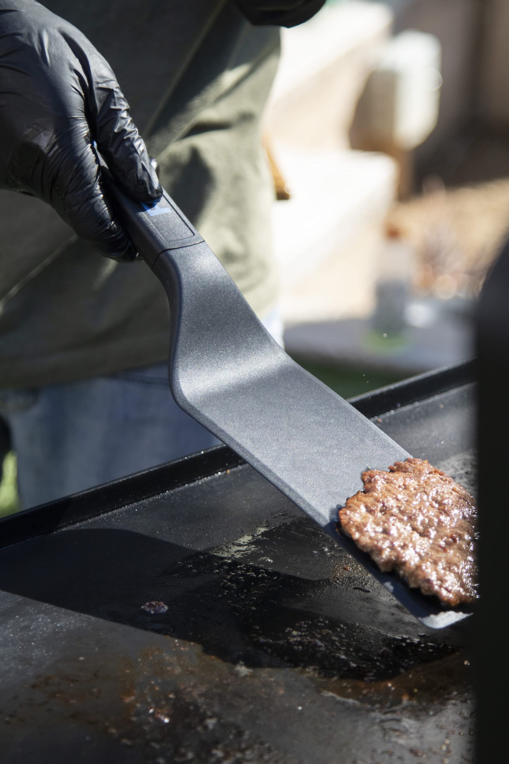 Pit Boss tools on hot griddle in use demonstrating cooking versatility