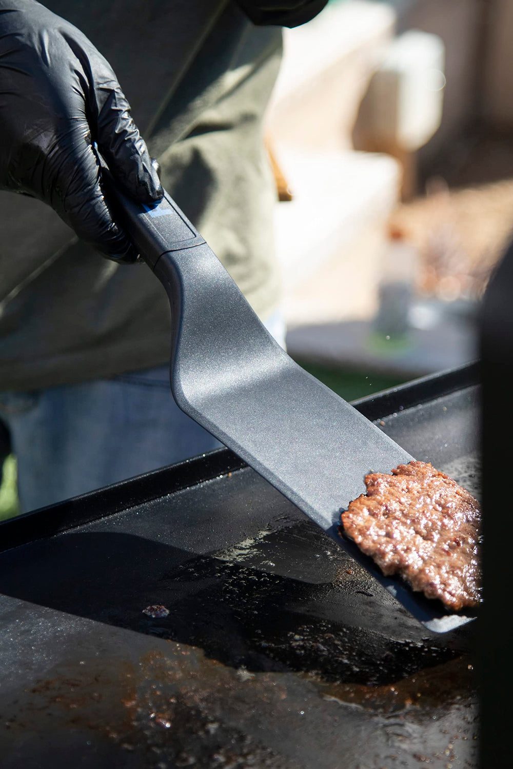 Pit Boss tools on hot griddle in use demonstrating cooking versatility