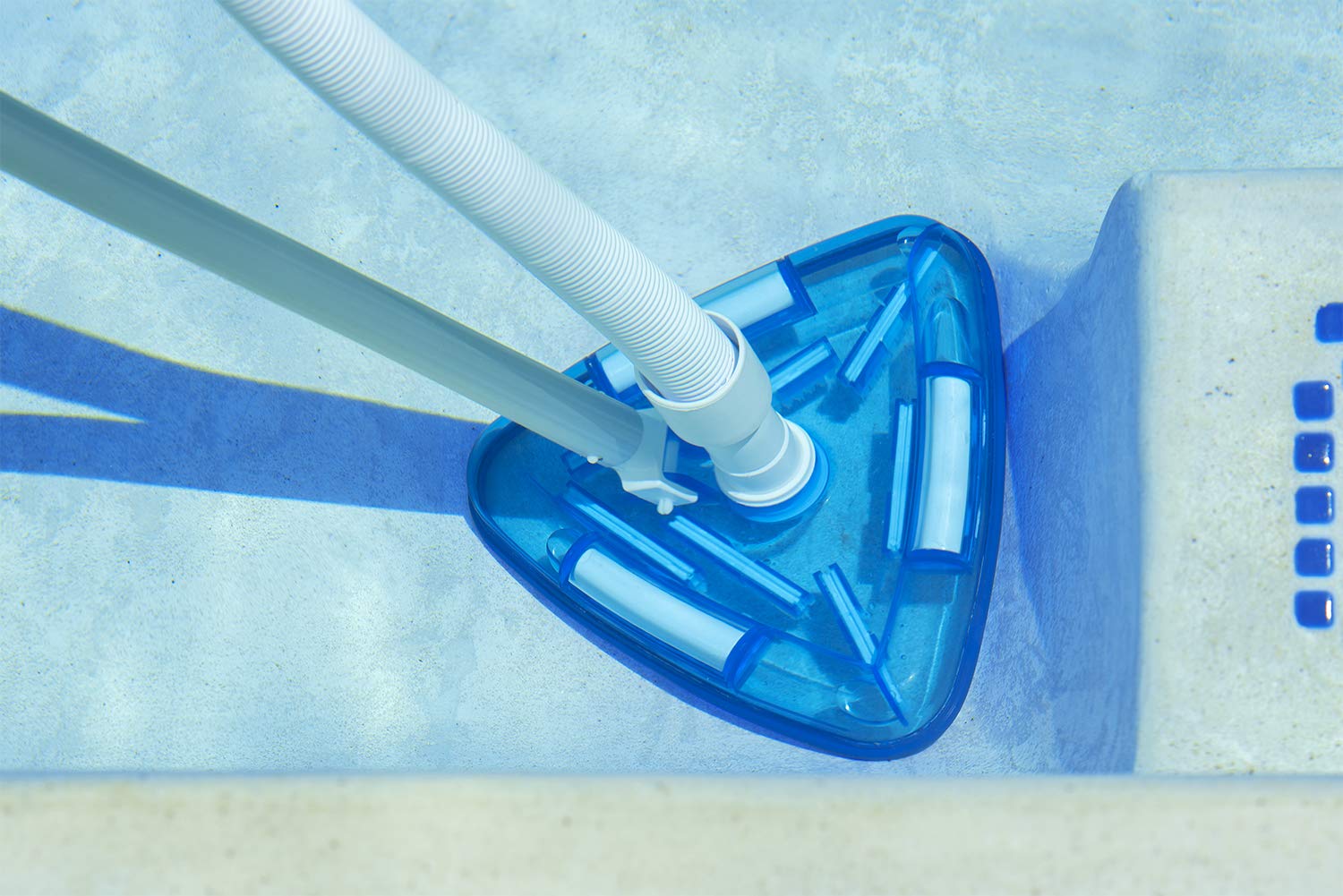 Poolmaster vacuum head in use on pool floor showing debris pickup