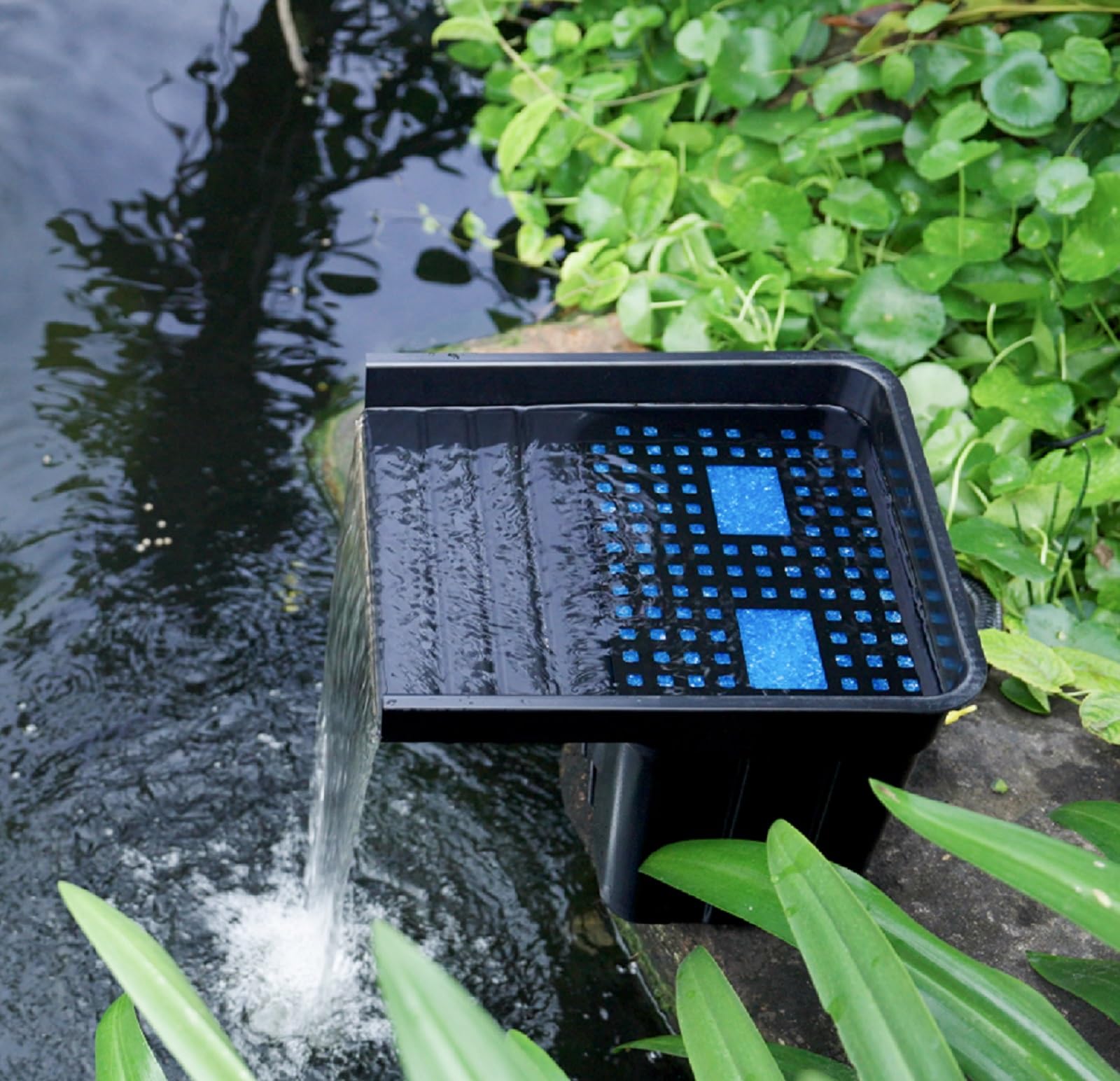 POPOSOAP backyard scene with waterfall showing tranquil aesthetic and garden focal point