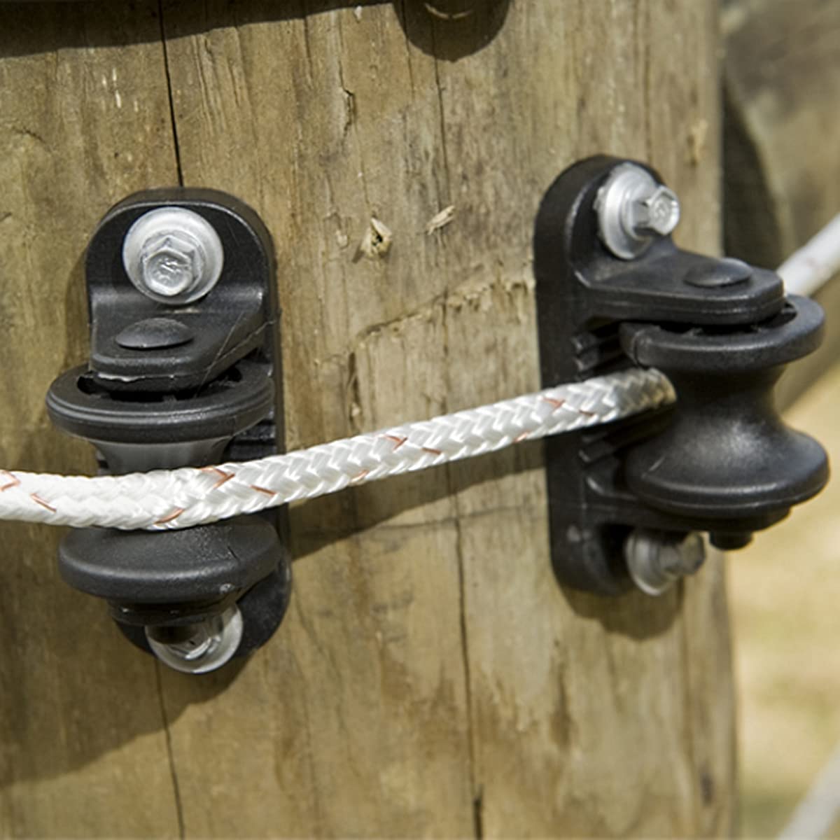 QMARK insulator beside ruler showing size and compatibility with common fence wire