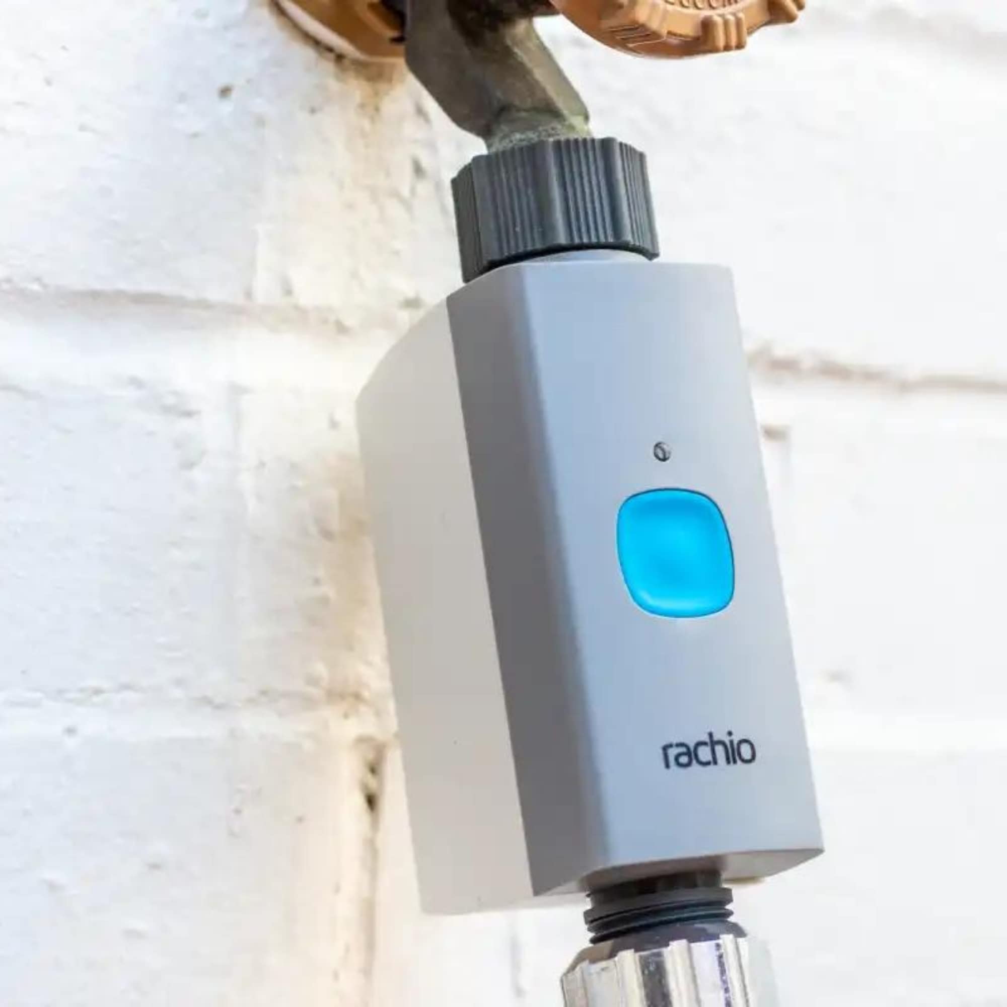 Rachio valve next to hand for scale showing compact size and portability benefit