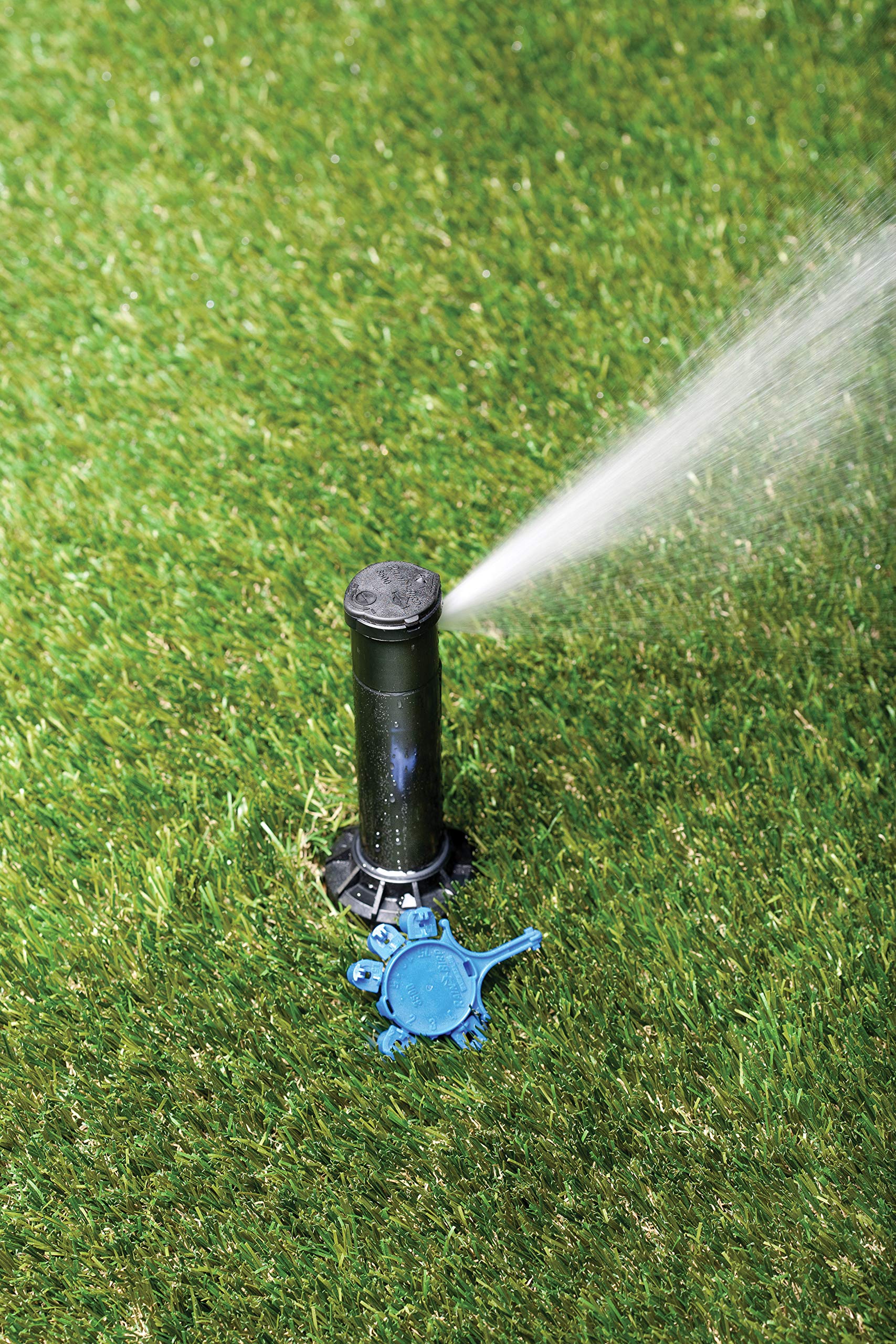 Rain Bird rotor installed in turf illustrating even watering and reduced overspray benefit