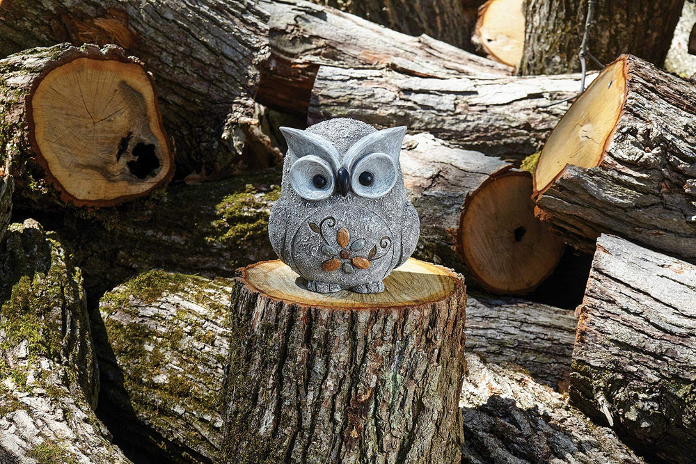 Roman pebble owl placed in garden near flowers for whimsical accent