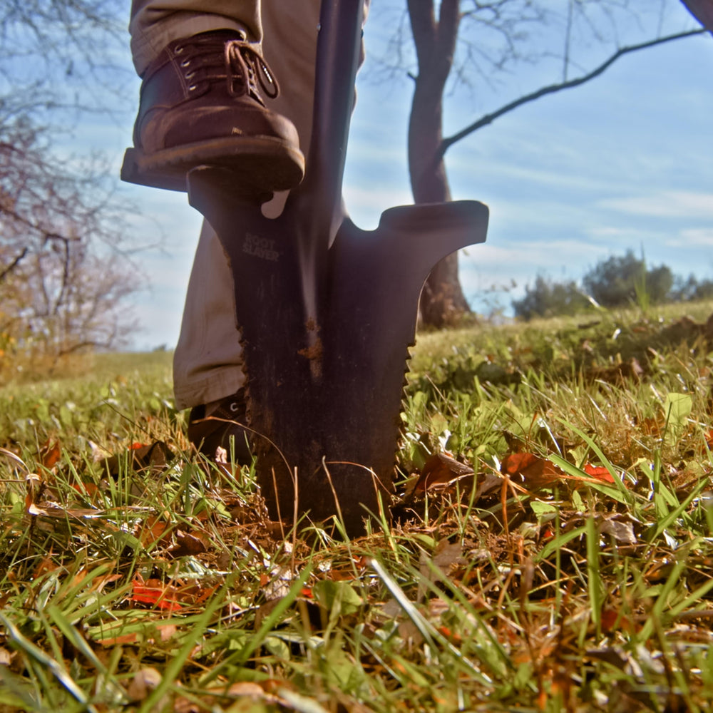 Root Slayer RS225 beside a boot for scale illustrating long handle length for improved reach