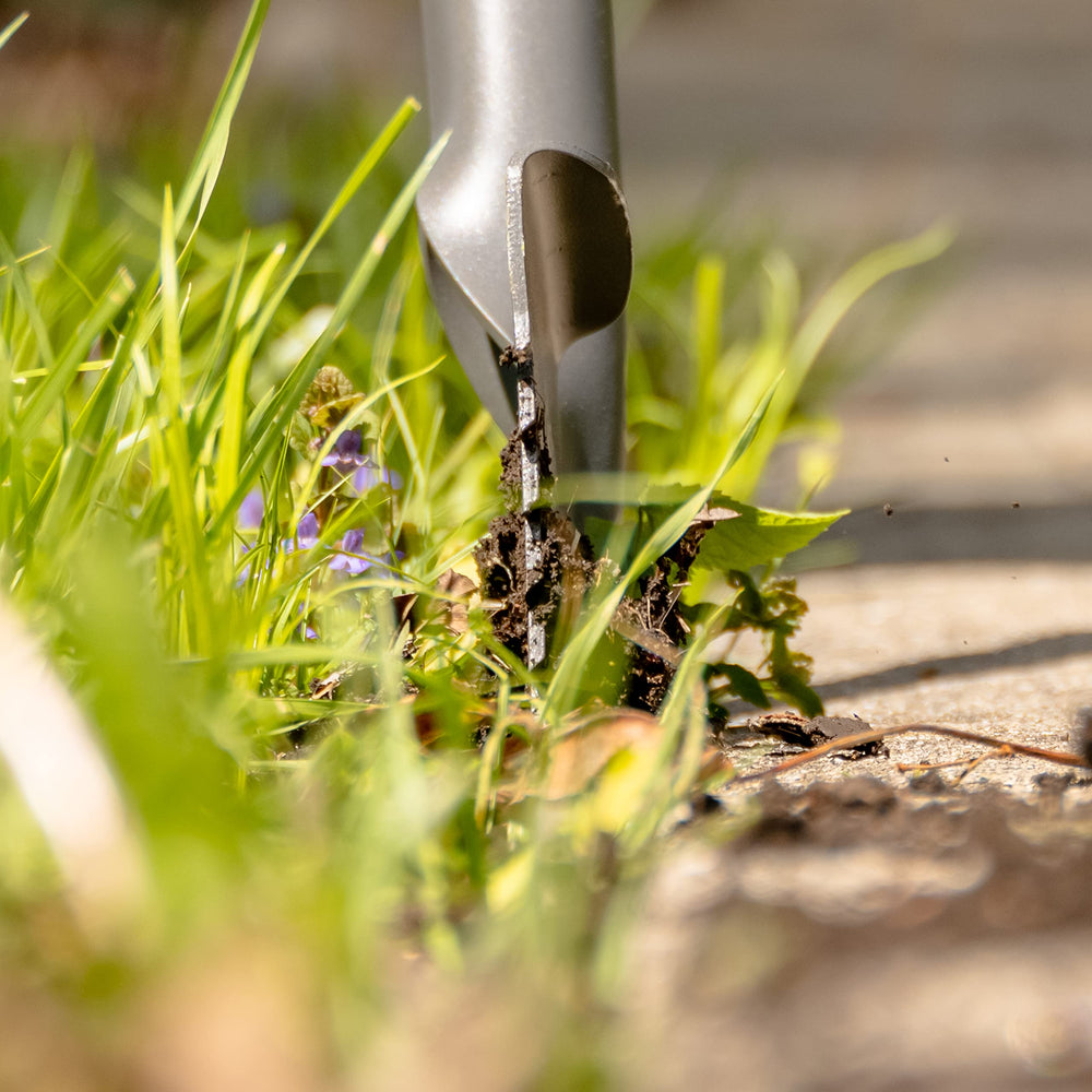Root Slayer blade penetrating turf and roots for efficient edging