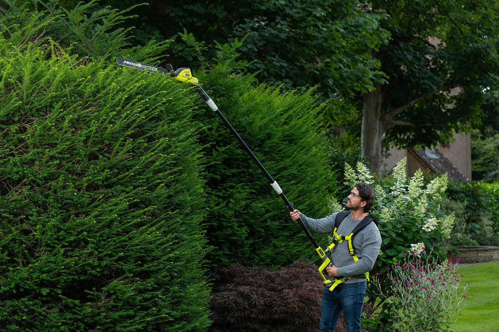 RYOBI trimmer in use cutting dense hedge for efficient yard maintenance