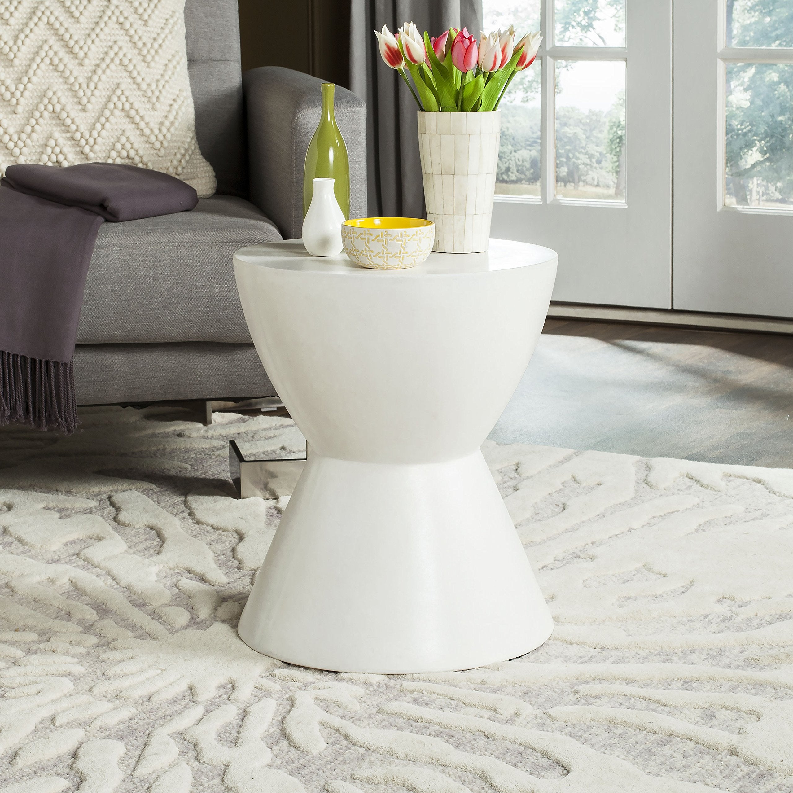 SAFAVIEH Athena next to sofa for scale showing compact footprint and styling versatility