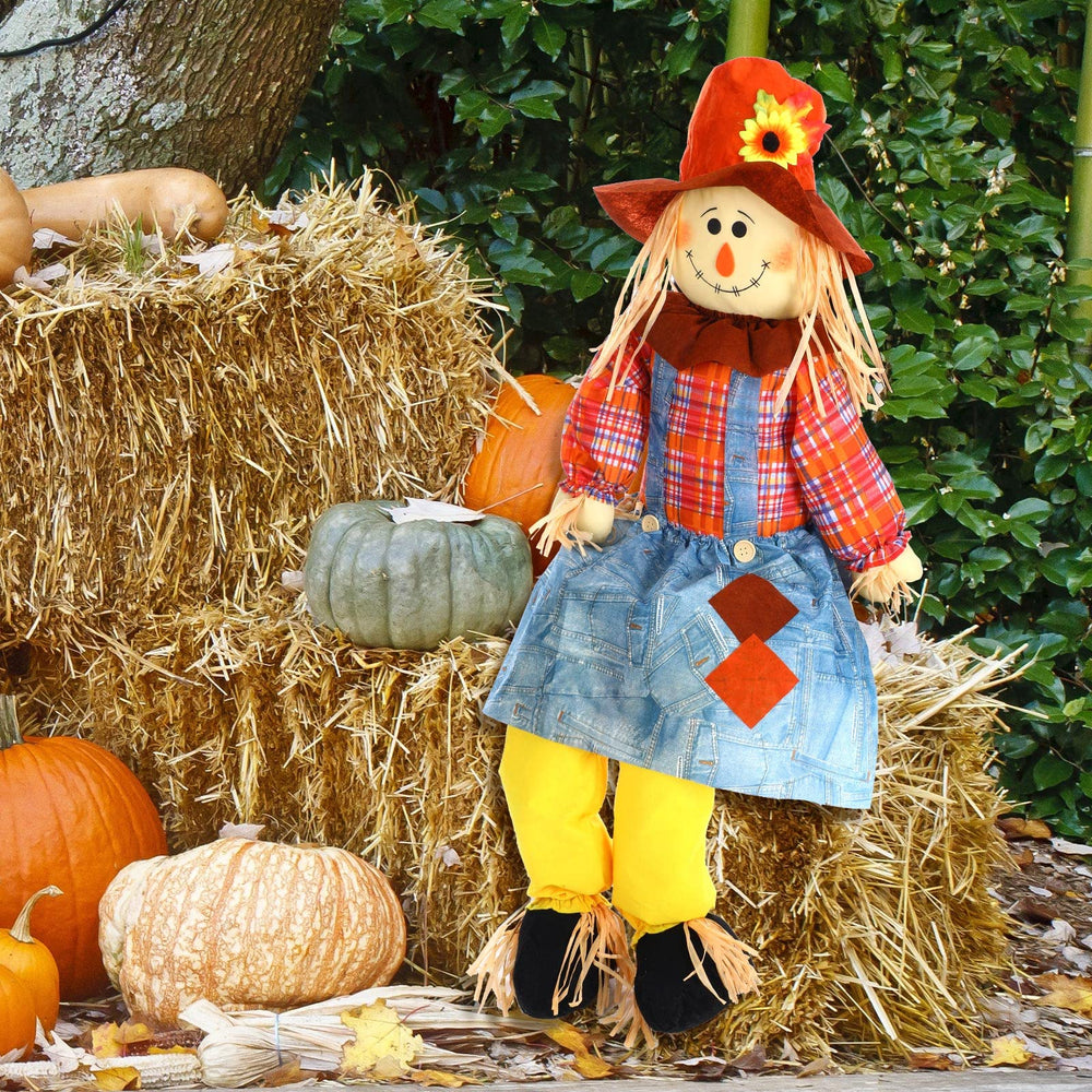 Shappy scarecrow styled with pumpkins and hay bales creating a harvest display