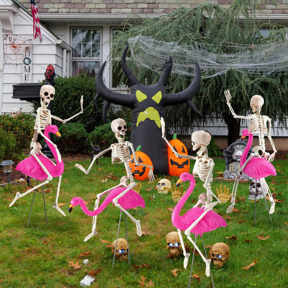 Simgoing yard display with flamingos and skeletons creating playful spooky atmosphere for visitors