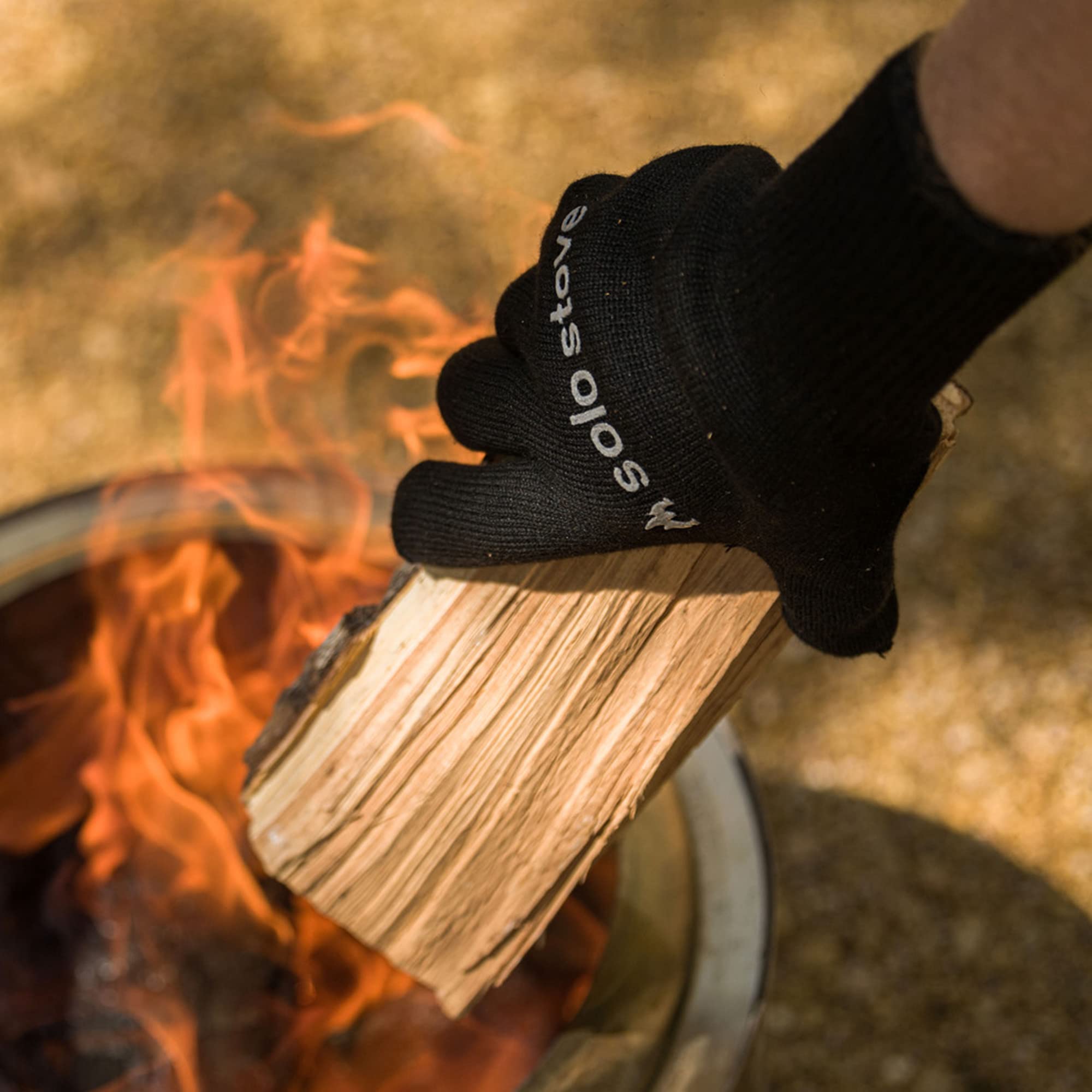 Solo Stove gloves next to hand showing one-size flexible fit