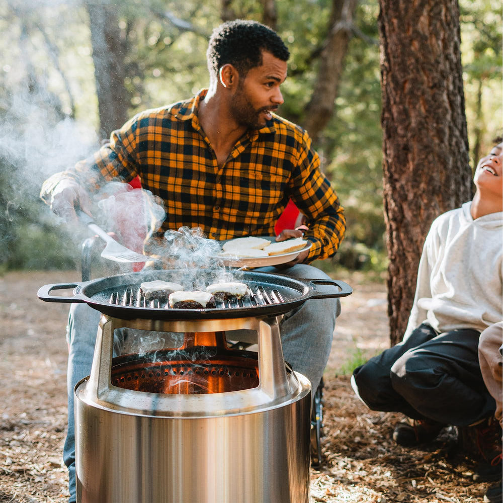Solo Stove grill with cast iron pan on surface demonstrating versatile cooking and benefit of multi-use