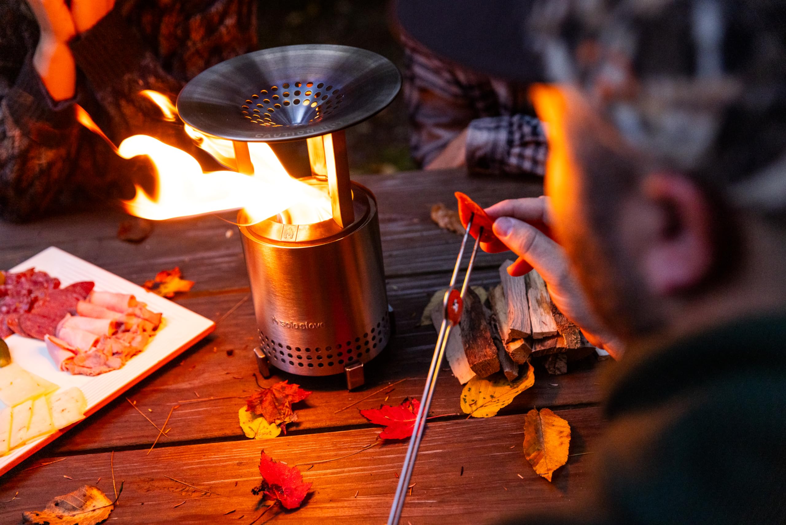 Solo Stove deflector beside a hand for scale, compact and portable benefit