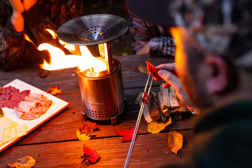 Solo Stove deflector beside a hand for scale, compact and portable benefit