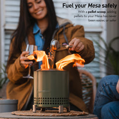 Solo Stove pellet scoop held above Mesa for safe, precise pellet placement and reduced spillage