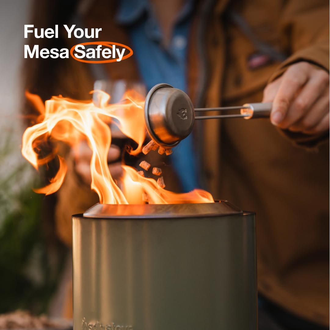 Solo Stove pellet scoop in hand for safer pellet placement and controlled fueling