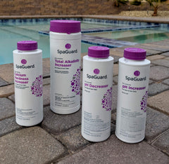 SpaGuard pH decreaser being poured with clear dosage markings for precise correction