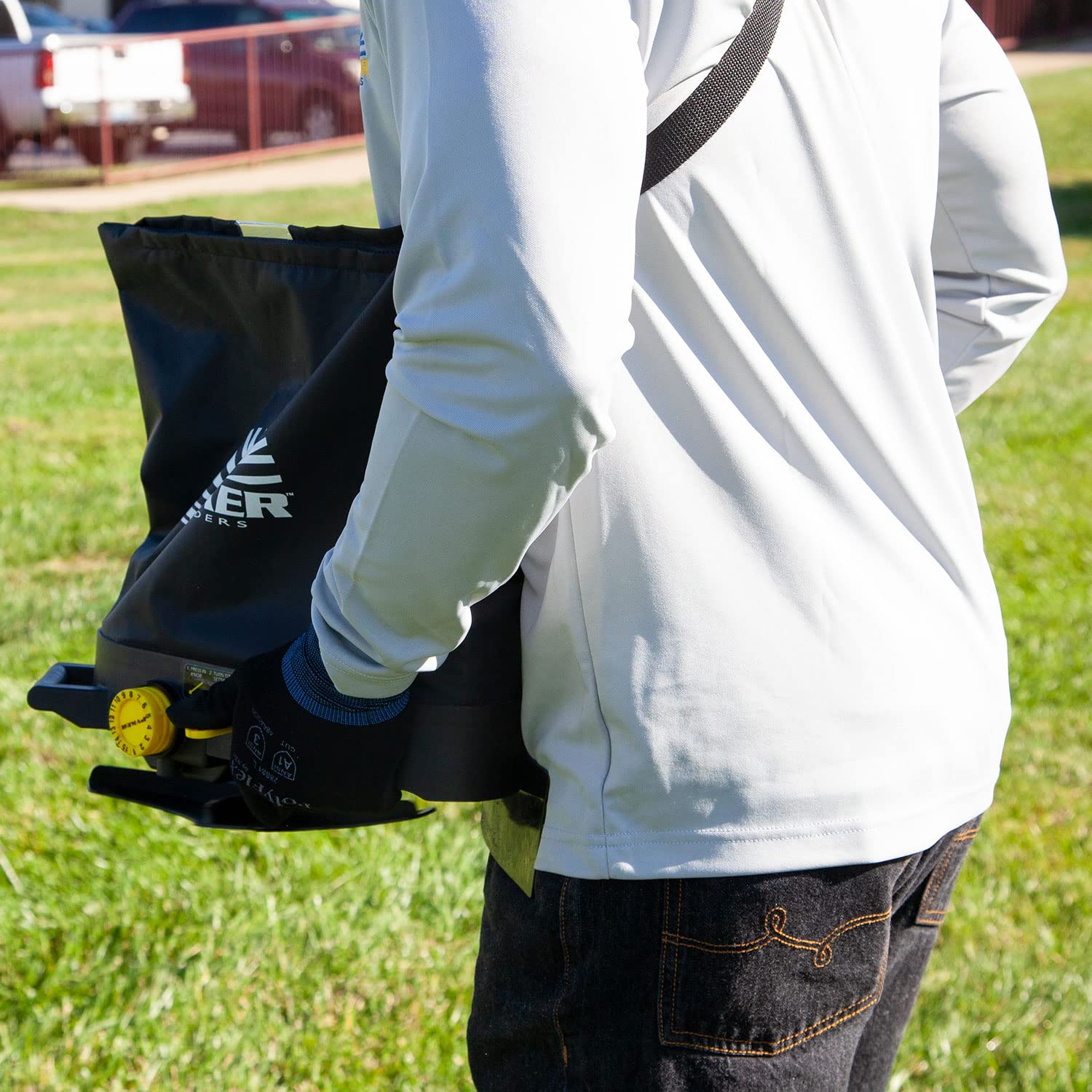 Spyker broadcast shield directing material and protecting user from overspray and debris