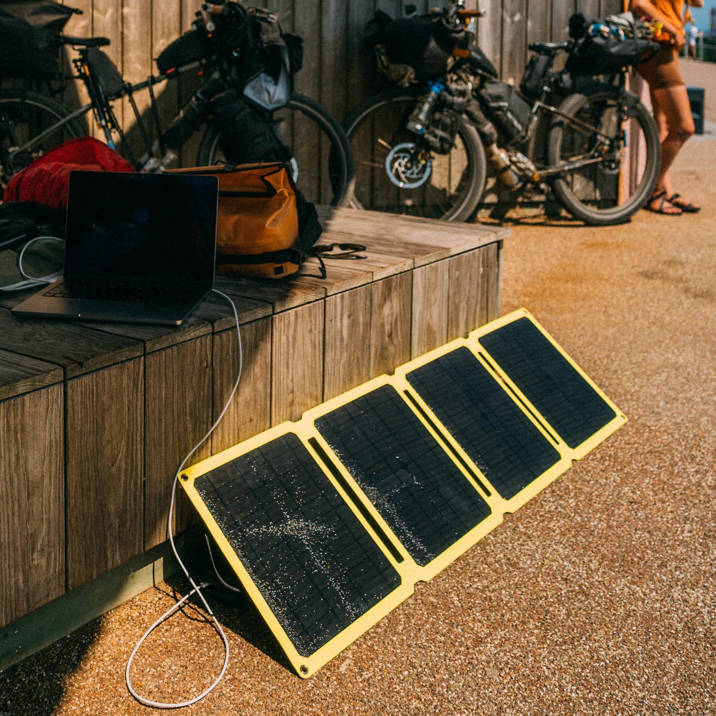 SunJack next to laptop showing scale and ability to top-up laptops