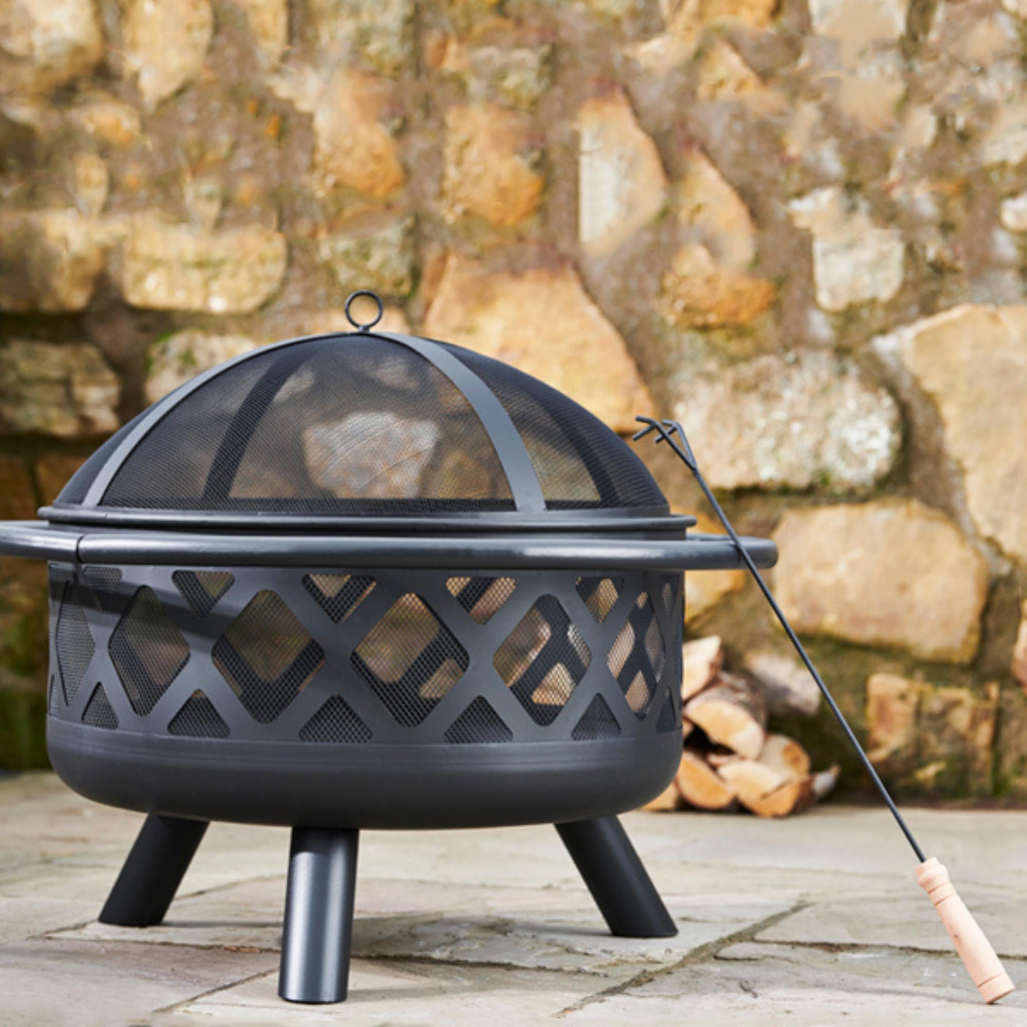 Teamson Home fire pit lit at dusk creating warm ambiance for outdoor entertaining