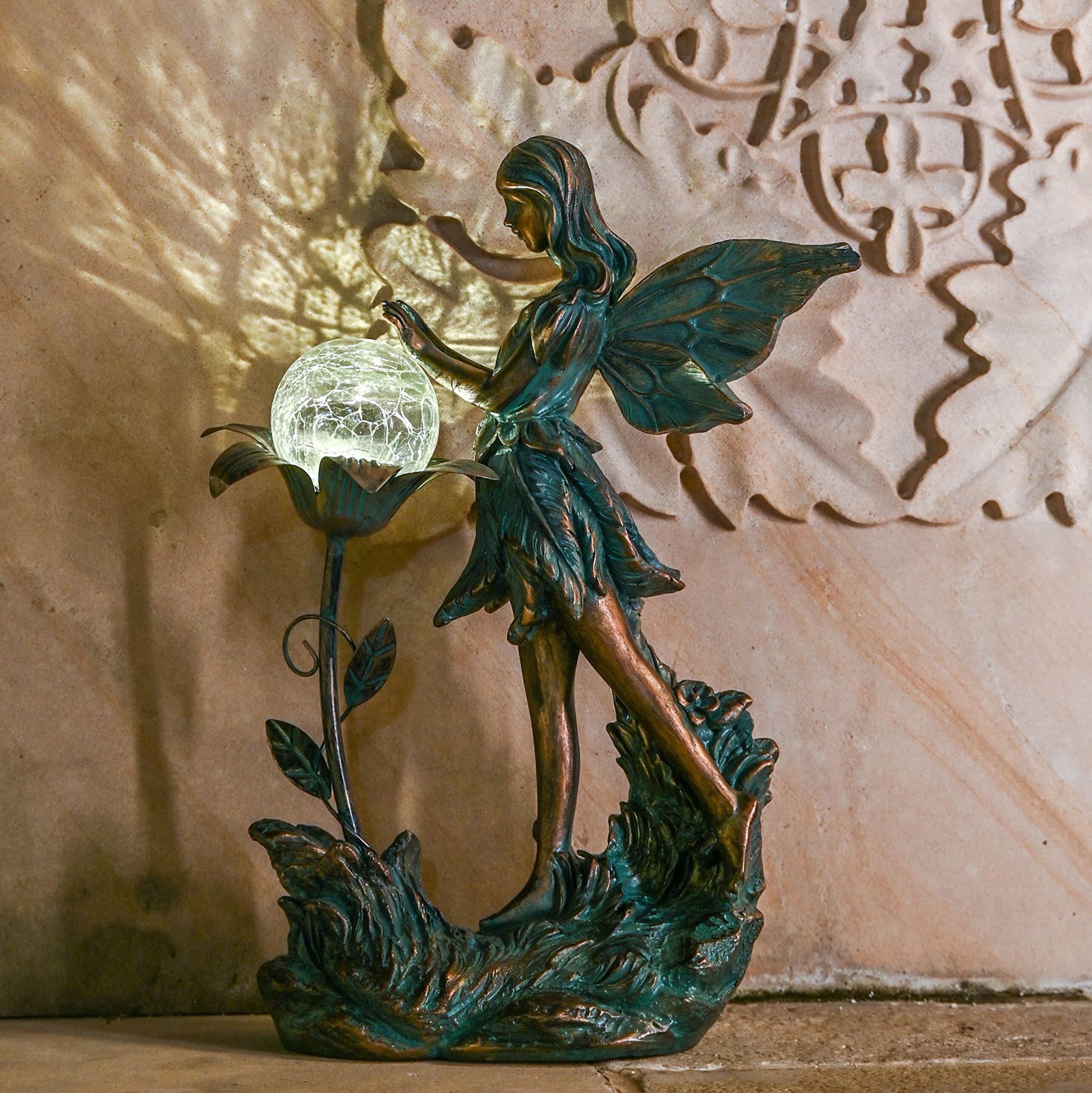 TERESA'S COLLECTIONS nighttime glow of fairy statue providing soft garden illumination