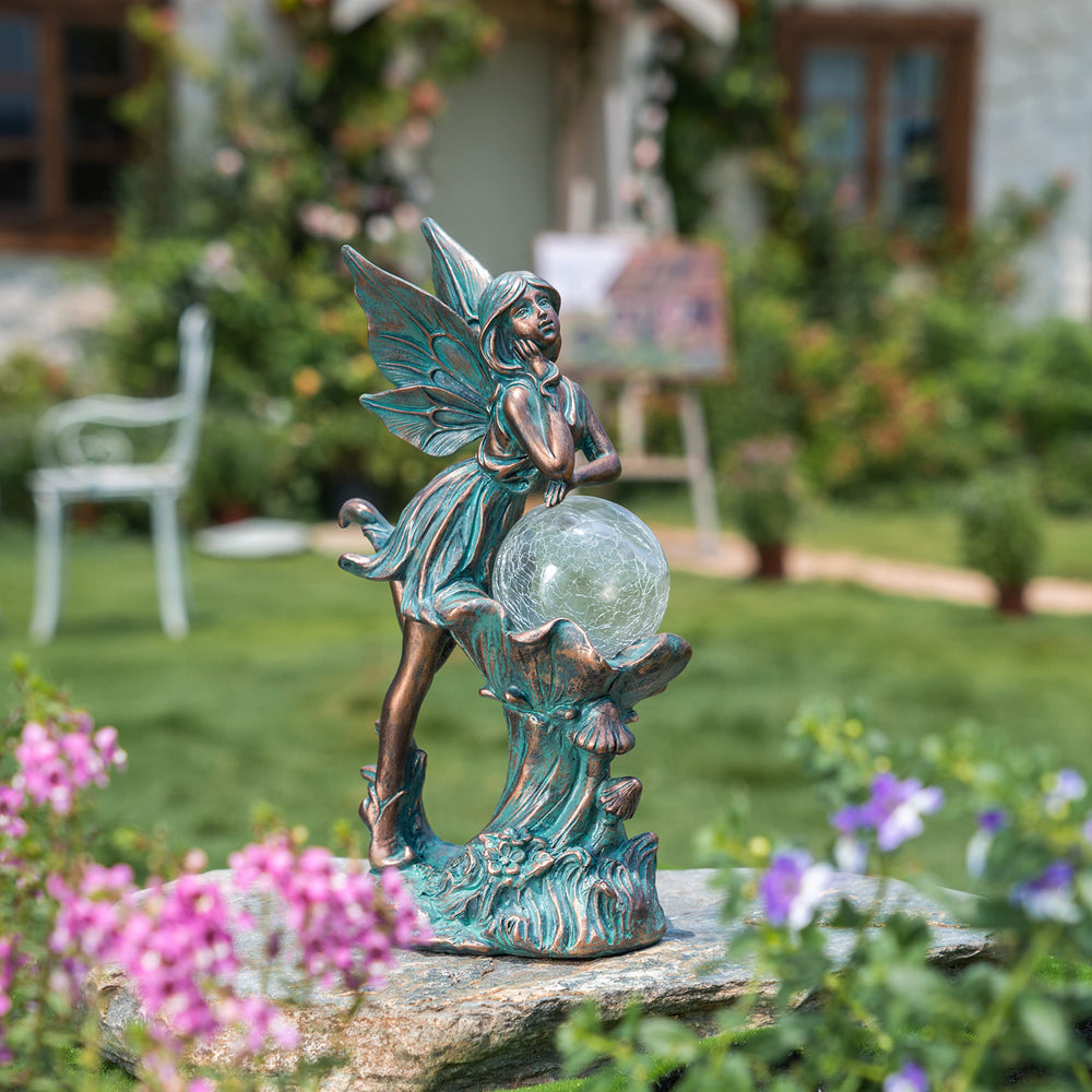 TERESA'S COLLECTIONS garden setting with statue lit at dusk creating ambient lighting
