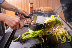 Traeger spatula flipping a burger on a griddle showing strong leverage and control