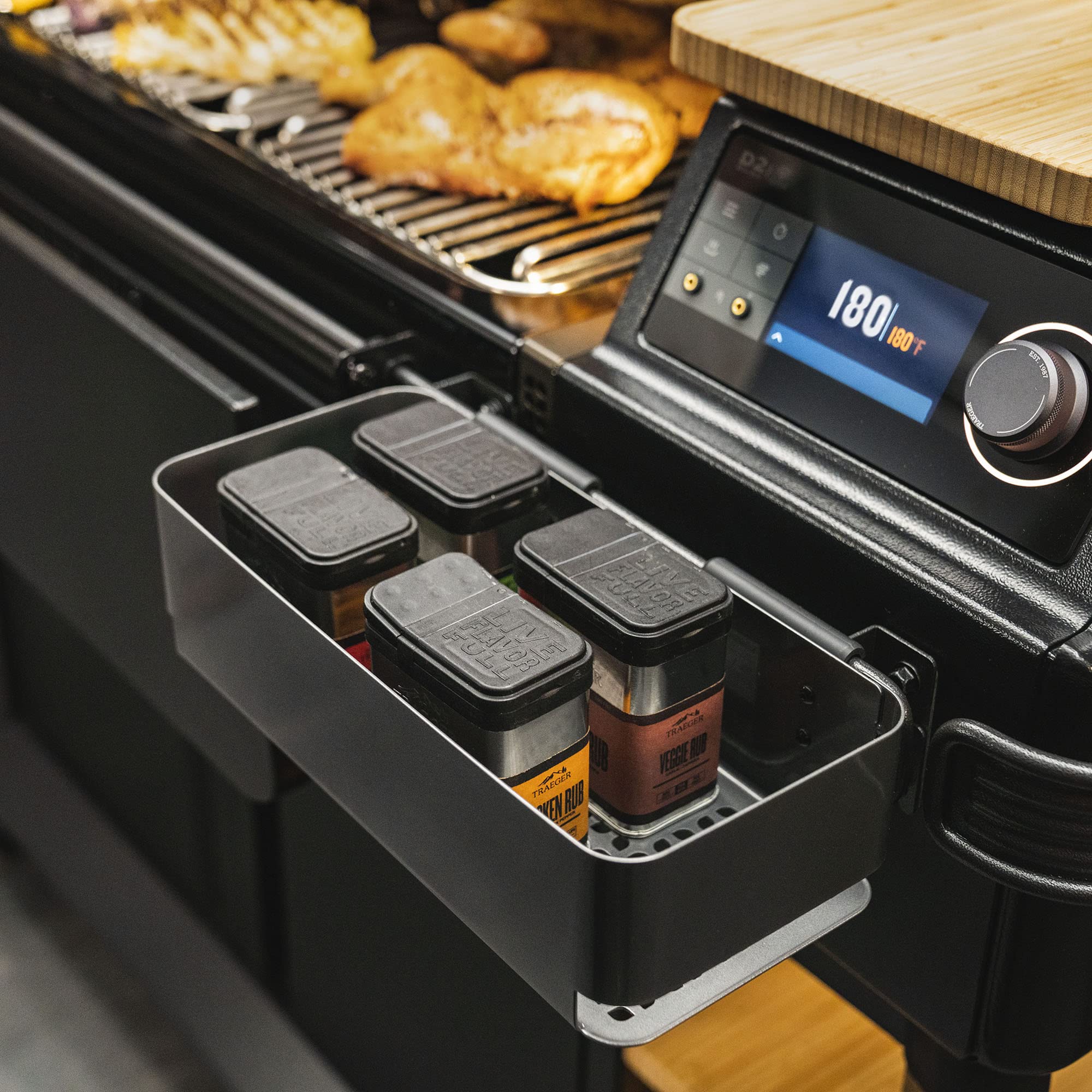 Traeger lifestyle shot of grill with storage bin keeping sauces and tools handy
