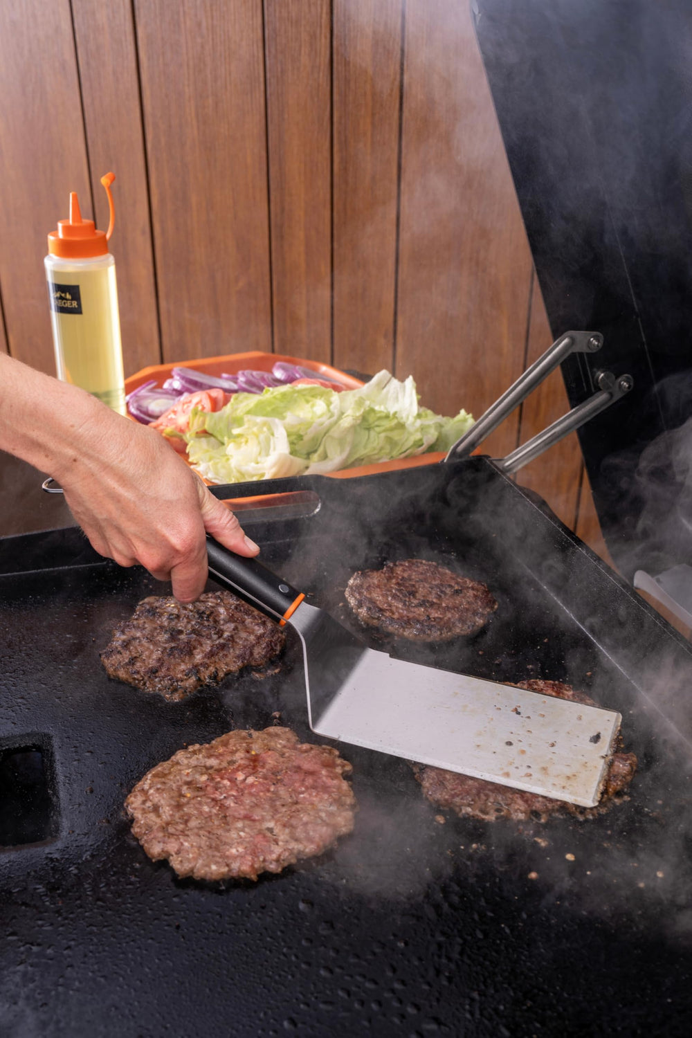Traeger press flattening a smash burger for crispy edges and even browning
