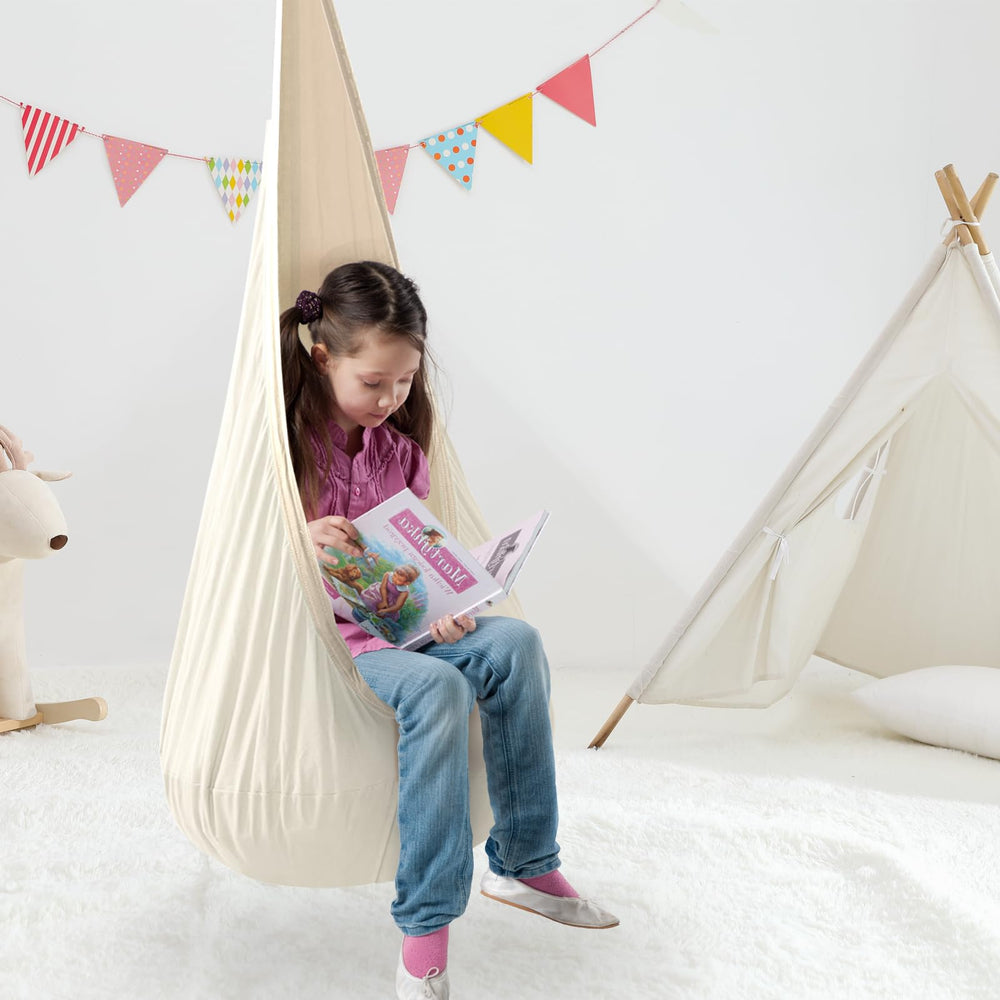 TRAVELBAIC child using cream pod swing reading, promoting calm focused play