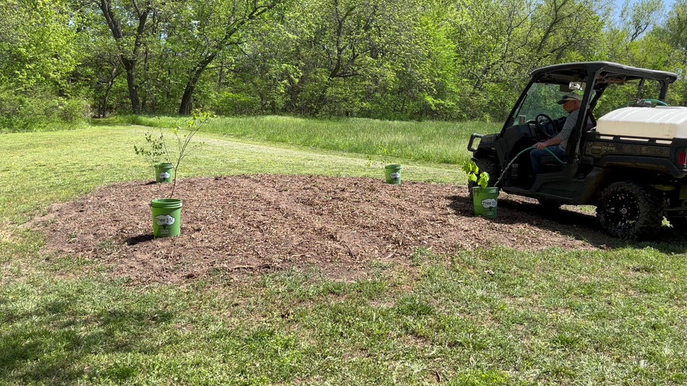 Tree I.V. reservoir beside shovel for scale, showing 5-gallon capacity advantage