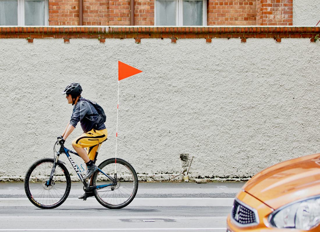 Uelfbaby kids riding with flag demonstrating safer family cycling outdoors