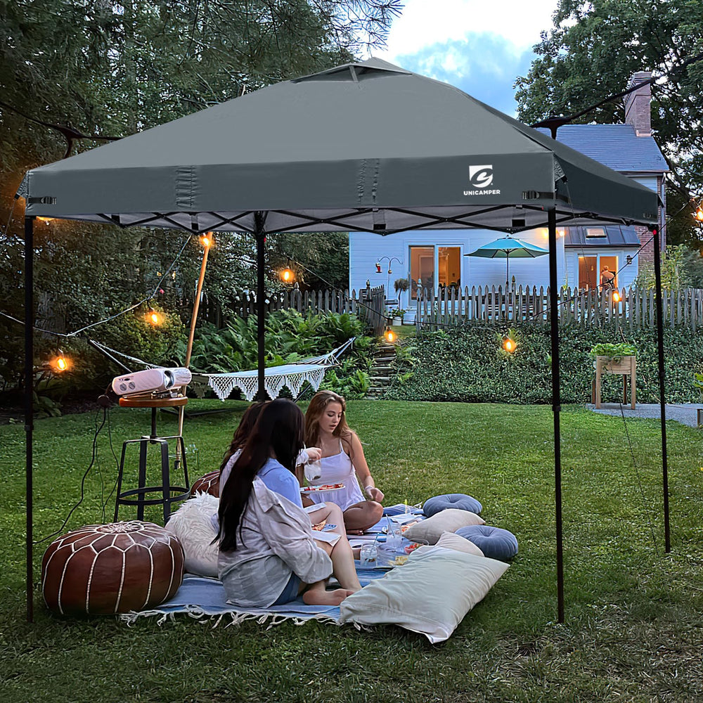 UNICAMPER canopy top with person for scale demonstrating true 10x10 footprint