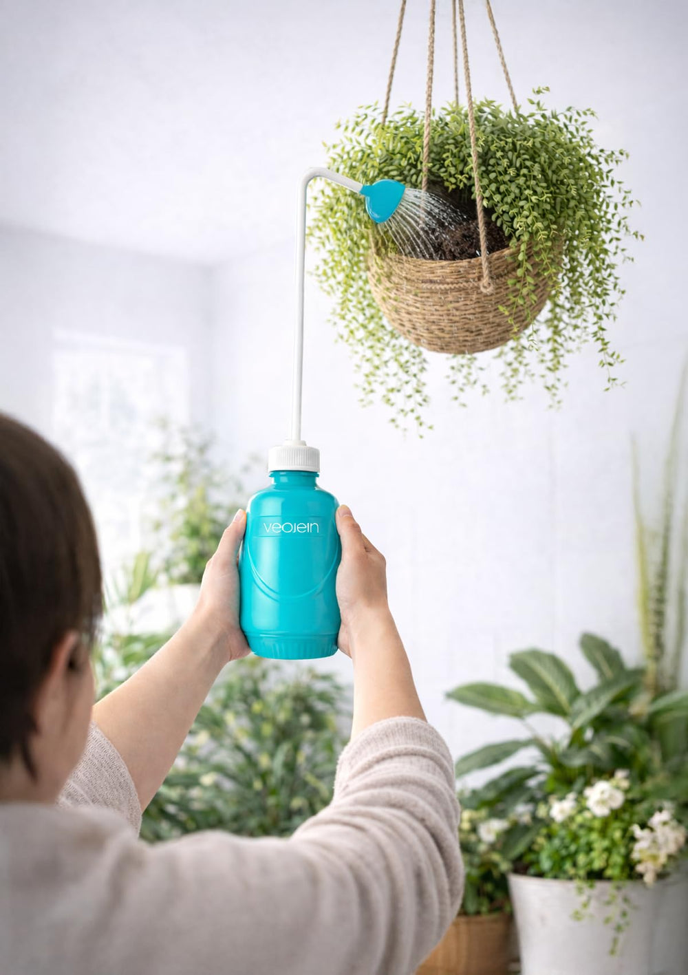 VEOJEIN bottle in use watering a hanging basket to reach soil without a stool